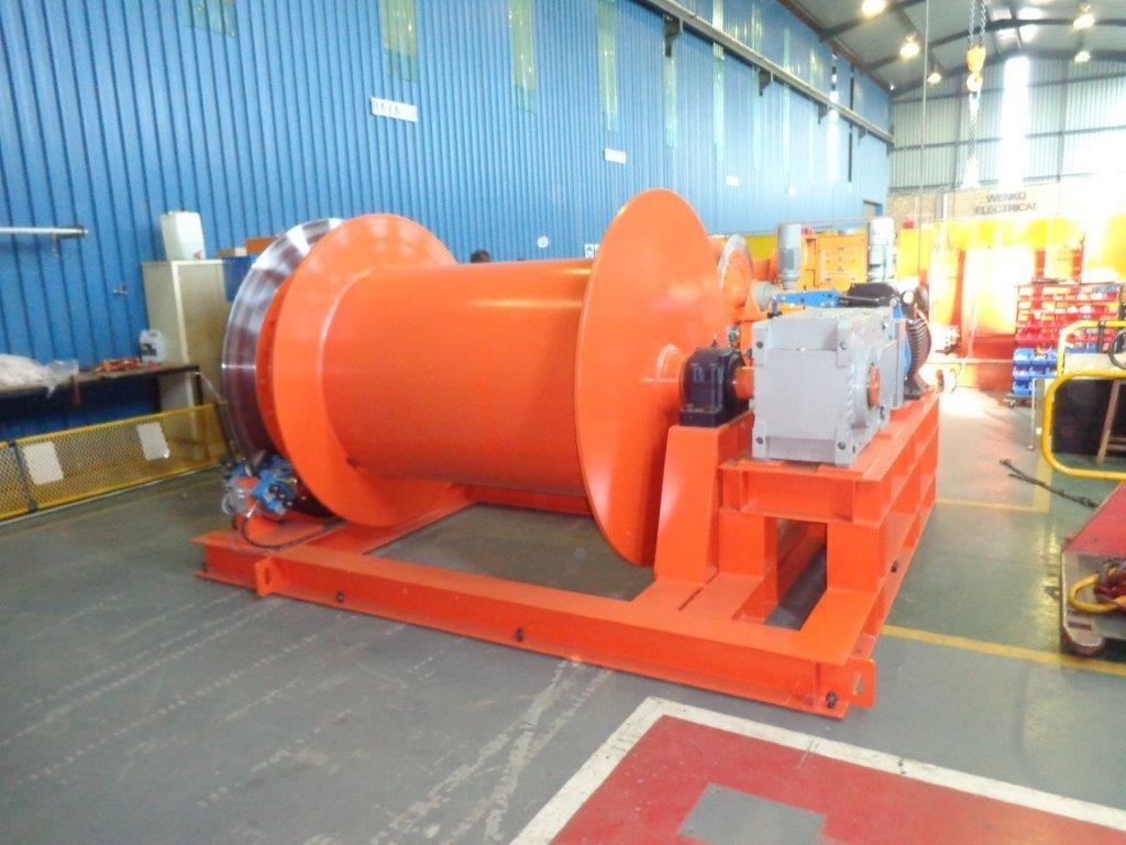 Side view of a Winches SA custom electric shaft winder showing the grooved drum, electric motor and gearbox drive train on a heavy structural-steel skid, manufactured in Silverton, Pretoria for the Gautrain shaft-sinking programme