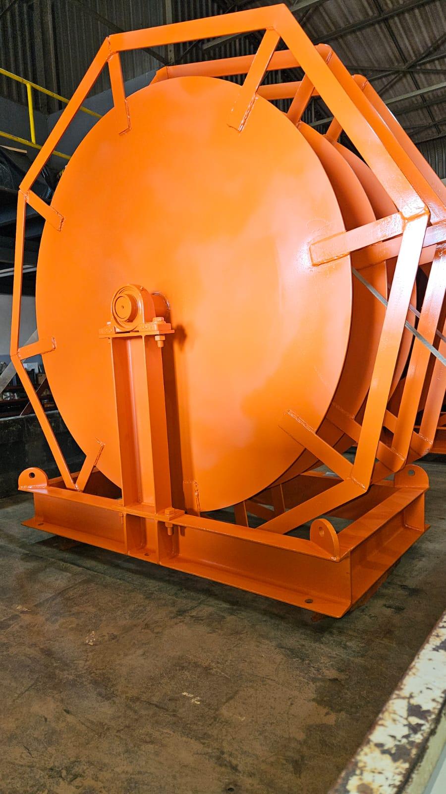 Wide-flange welded steel drum of a Winches SA heavy-duty electric cable reeler in a hexagonal structural-steel skid frame, custom-manufactured in Silverton, Pretoria for Pan African Resources MTR mine dewatering