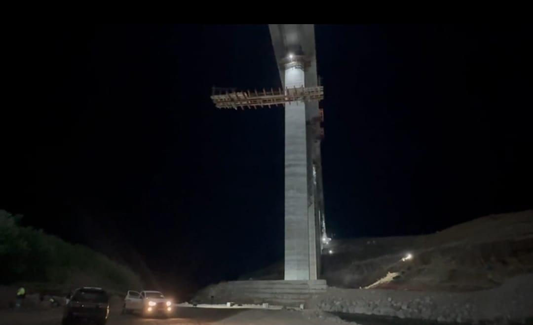 A Senqu Bridge deck section suspended at night from the bridge pier during construction, during construction on the Lesotho Highlands Water Project Phase II